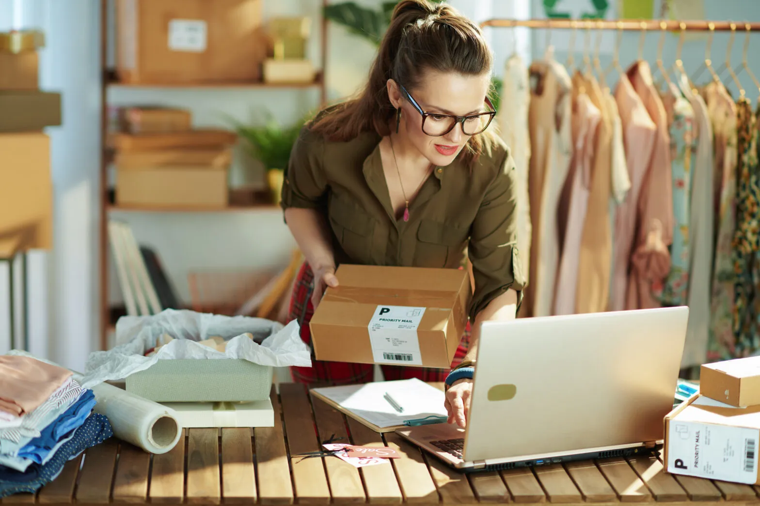 A woman running an ecommerce business packing orders ready for shipping