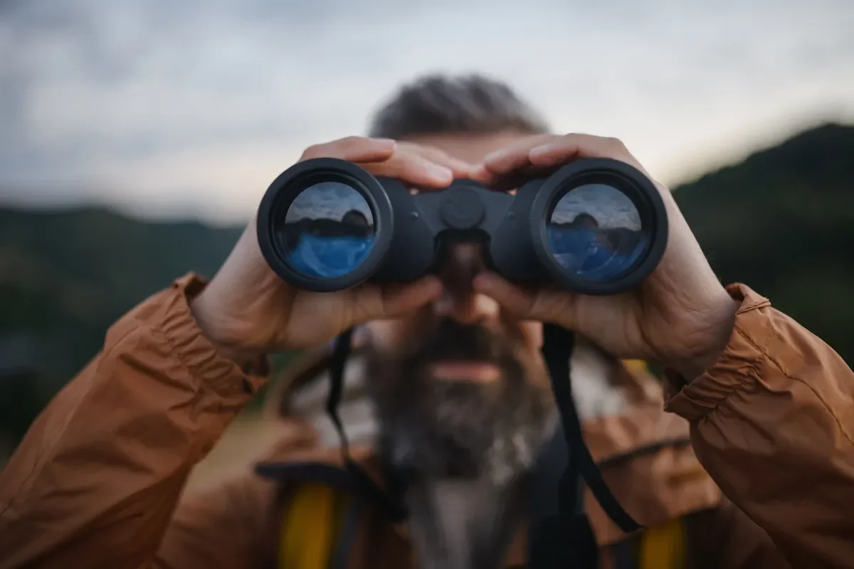 A man looking through binoculars